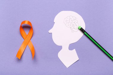 Kağıt insan kafası ve eflatun kaplama turuncu kurdele. Çoklu Skleroz Farkındalık Ayı