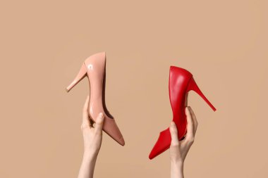 Kahverengi arka planda farklı stil yüksek topuklu kadın elleri