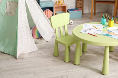 Rahat çocuk odasında sandalyeli bir masa.