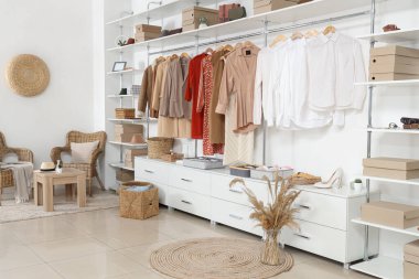 Soyunma odasında farklı kıyafetleri ve aksesuarları olan büyük gardırop.