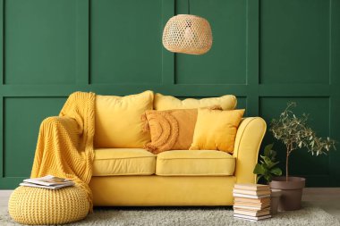 Sarı kanepe, puf ve kitapların olduğu şık bir oturma odası.