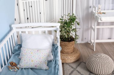 Çocuk odasının içinde rahat bir bebek beşiği.