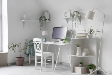 Programcı masası ve bitkileri olan ışık ofisinin içinde.