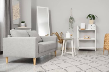 Rahat kanepesi, sehpası ve halısı olan aydınlık modern oturma odası.