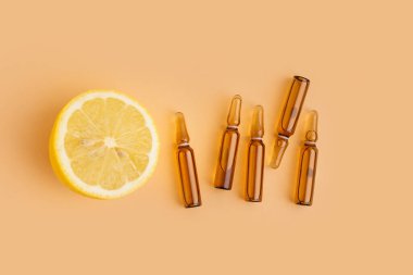 C vitamini ampulleri ve arka planda yarım limon