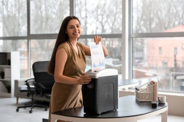 Shredder 'ı kullanarak belgeleri yok eden genç sekreter.