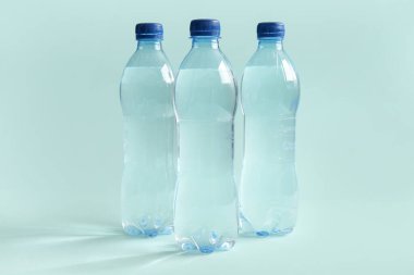 Mavi zemin üzerinde plastik temiz su şişeleri