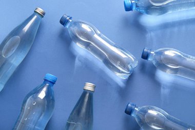 Mavi zemin üzerinde plastik temiz su şişeleri