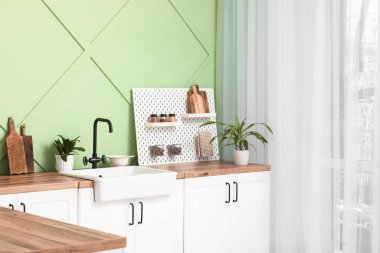 Tahta, ev bitkileri ve mutfak penceresinin yanında lavabo