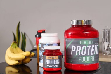 Mutfaktaki masada muzlu kavanozlar dolusu protein tozu, yakın plan.