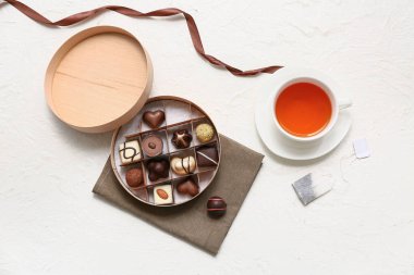 Bir kutu şeker, bir fincan çay ve arka planda çay poşeti.