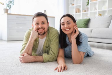 Genç çift evdeki yumuşak halıda yatıyor.