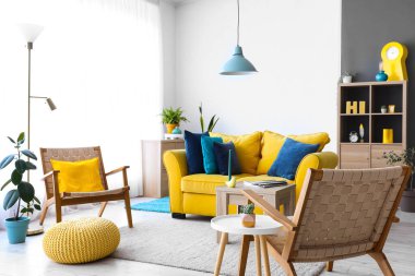 Sarı koltuklu ve koltuklu şık bir oturma odası.