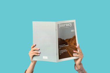 Mavi arka planda şarjörü olan bir kadın.