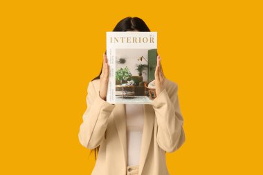 Sarı arka planda günlüğü olan güzel genç bir kadın.