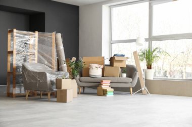 Taşındığı gün oturma odasında kanepe ve karton kutular var.