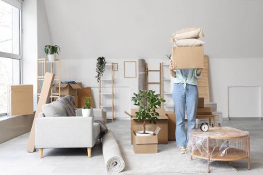 Taşındığı gün oturma odasında karton kutuları olan genç bir kadın.