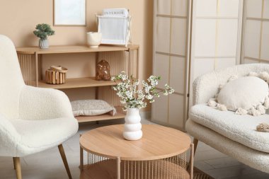 Oturma odasının iç tarafındaki masada açan dallar.