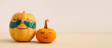 Yüzleri çizilmiş şirin balkabakları ve ışık arka planında göz altı yamaları ve metin için yeri olan sevimli balkabakları. Spa konsepti