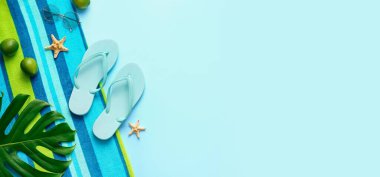 Plaj aksesuarları, limonlar ve açık mavi arkaplan üzerinde palmiye yaprağı ile kompozisyon metin için boşluk