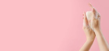 Pembe arkaplanda sabun ve metin için boşluk olan eller