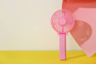 Renkli arka planda mini pembe elektrikli fan