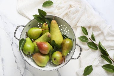 Beyaz mermer masa üzerinde olgun armutlar ile Colander