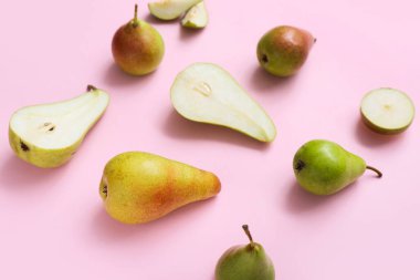 Pembe arka planda farklı olgun armutlar