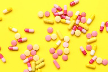 Sarı arka planda bir sürü farklı hap var.