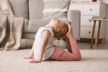 Cute little girl doing gymnastics at home