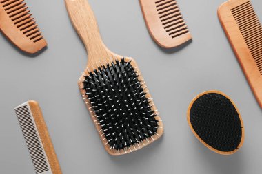 Gri arkaplanda saç fırçaları ve taraklar