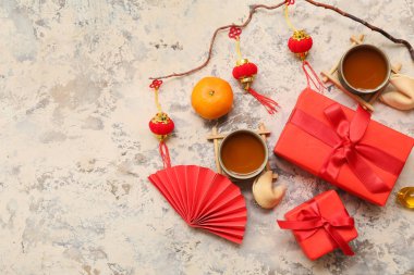 İçinde çay fincanları, fal kurabiyeleri ve arkaplanda Çince semboller olan hediye kutuları. Yeni yıl kutlaması