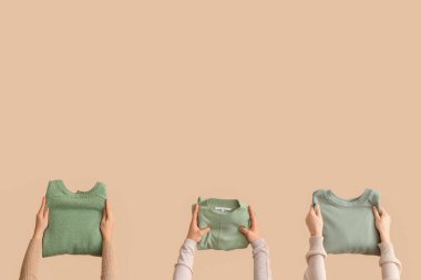 Bej arka planda katlanmış kazaklı kadınlar