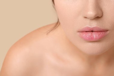 Arkaplanda pembe ruj izi olan genç bir kadın, yakın plan.