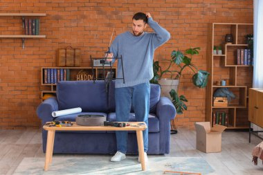 Sorunlu genç adam evde pouf topluyor.