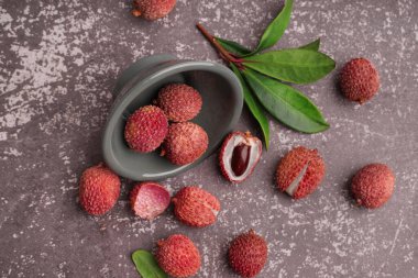 Arkaplanda lezzetli litchi meyvesi olan bir kase.
