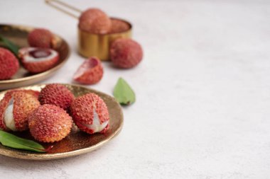 Hafif arka planda lezzetli litchi meyveli tabak, yakın plan.