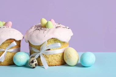 Lezzetli Paskalya pastaları ve renkli arka planda boyanmış yumurtalar. Yakın çekim.