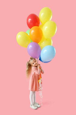 Pembe arka planda renkli balonları olan mutlu, küçük bir kız.