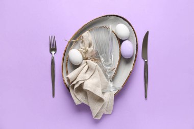 Paskalya yumurtaları ve leylak arkaplanda çingene çiçekleri olan güzel bir masa.