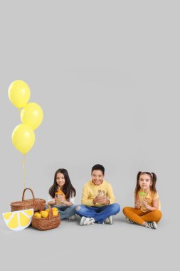 Hafif arka planda limonatası olan şirin çocuklar.