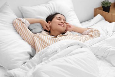 Mutlu genç bir kadın yatakta yatan