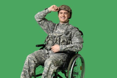 Yeşil arka planda tekerlekli sandalyedeki erkek asker.