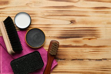 Ahşap arka planda fırçalar, fırçalar, kumaşlar ve ayakkabı cilası