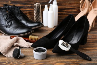 Ahşap arka planda parlak ayakkabılar ve ayakkabı temizleme araçları