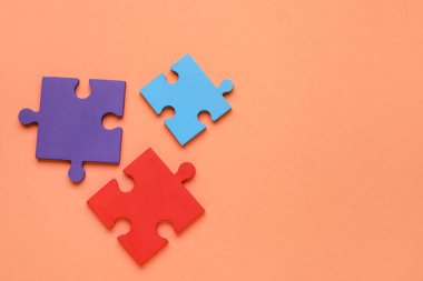 Turuncu arka planda renkli yapboz parçaları. Otistik bozukluk kavramı. Üst görünüm