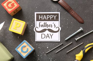 Yazılı kağıt Mutlu Babalar Günü ve farklı oğul ve baba aksesuarları siyah arka planda