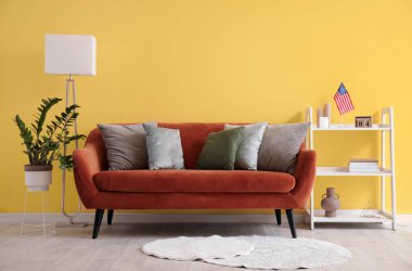 Modern oturma odasının içinde kahverengi kanepe ve raflarda Amerikan bayrağı var.