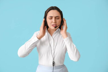 Mavi arka planda kulaklık takan kadın teknik destek ajanı