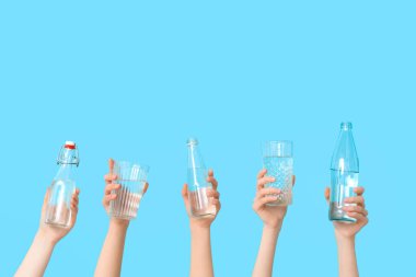 Renkli arka planda bardak ve su şişeleri olan kadın elleri